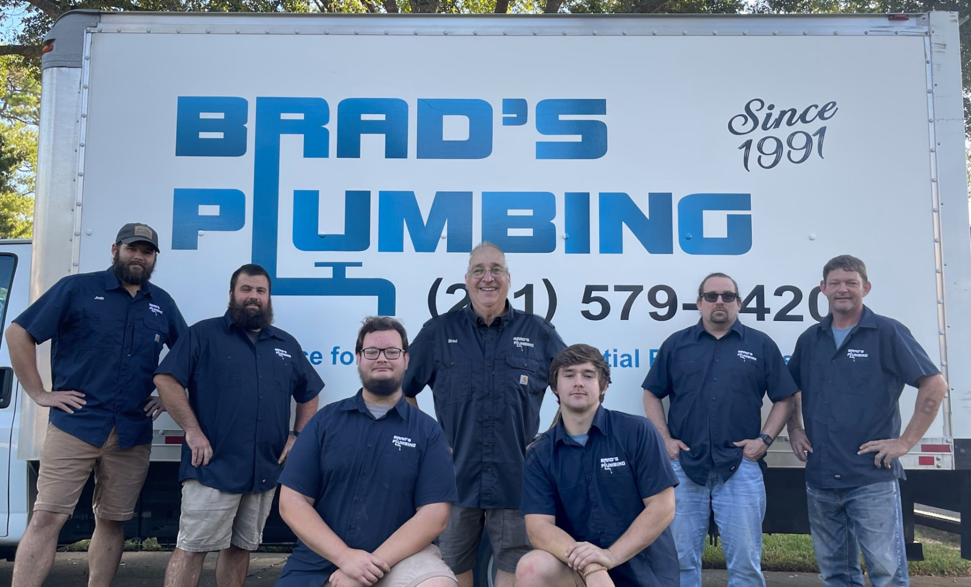 Brad's Plumbing team standing in front of the company truck